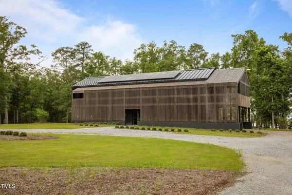 a front view of house with yard and trees in the background