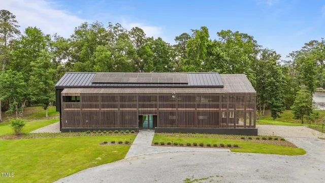 a view of a house with a backyard and a large tree