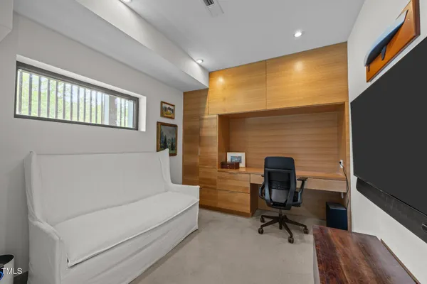 a view of a workspace with furniture and a window