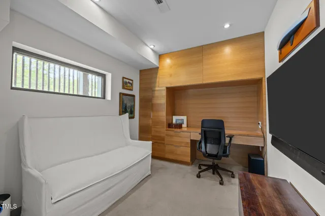 a view of a workspace with furniture and a window