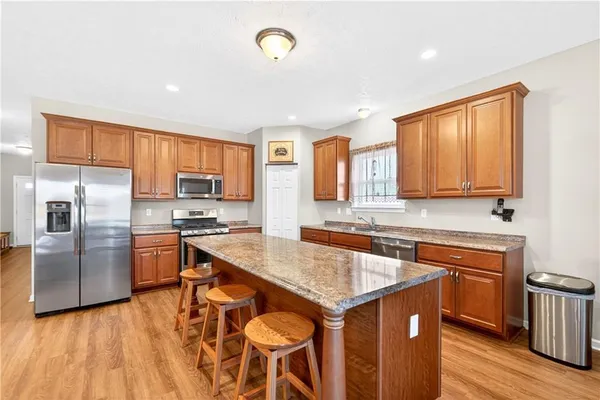 a kitchen with stainless steel appliances granite countertop a sink stove and refrigerator