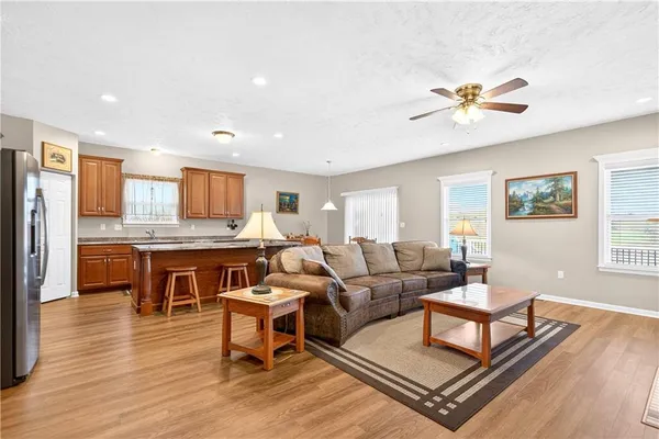 a living room with furniture a dining table wooden floor and a window