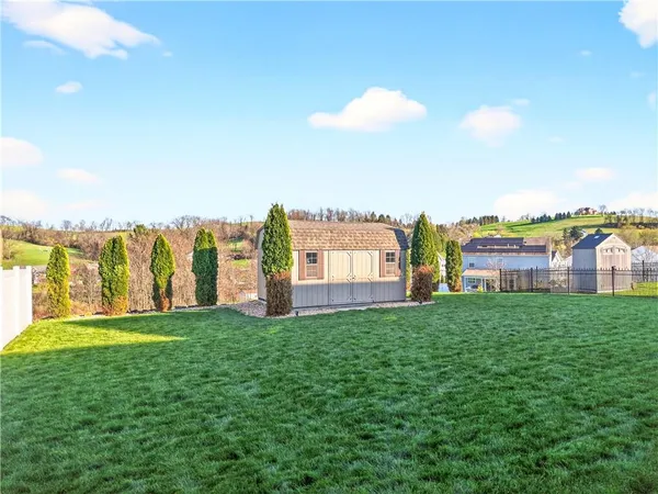 a view of a house with a big yard and a fountain