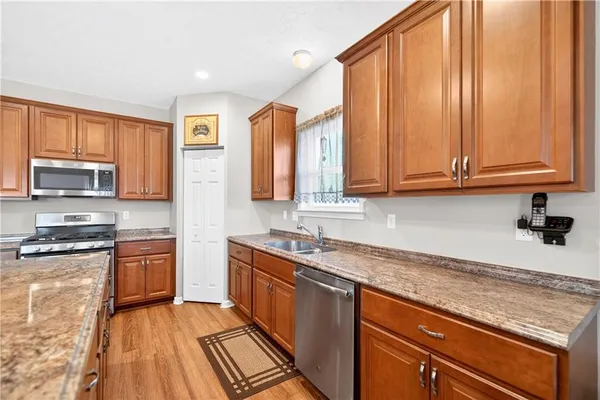 a kitchen with stainless steel appliances granite countertop a stove a sink and a microwave