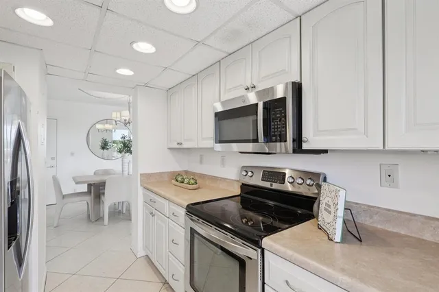 a kitchen with stainless steel appliances a stove a microwave a sink a refrigerator and cabinets