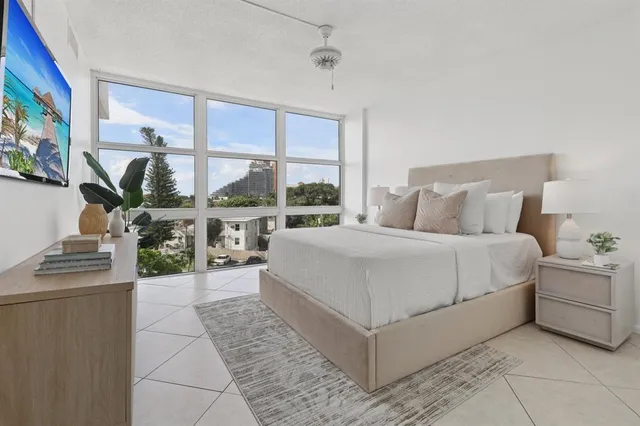 a bedroom with a bed and a large window