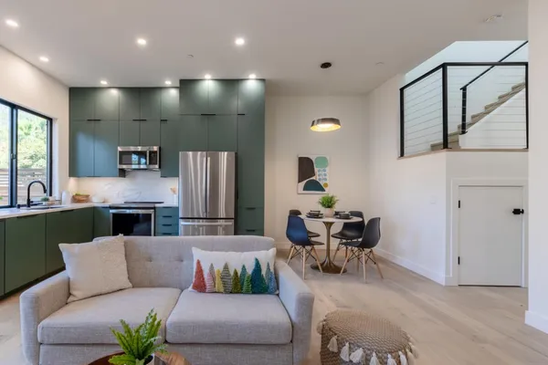 a living room with furniture kitchen view and a large window