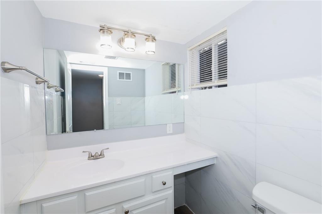 1277 Goodwin Road Northeast, Unit 1271 Atlanta, GA 30324 - Photo 15 of 19 a bathroom with a sink a toilet and mirror