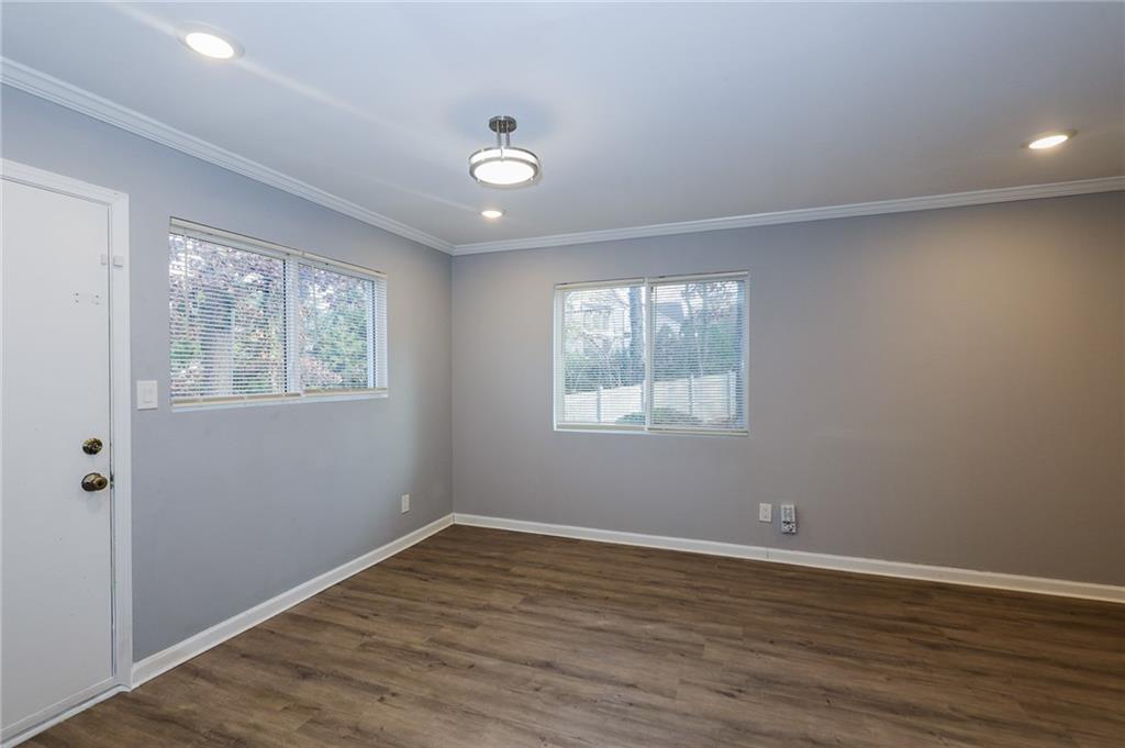 1277 Goodwin Road Northeast, Unit 1271 Atlanta, GA 30324 - Photo 2 of 19 an empty room with wooden floor and windows