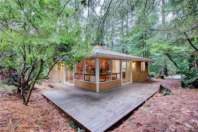 a view of a house with large yard and large trees