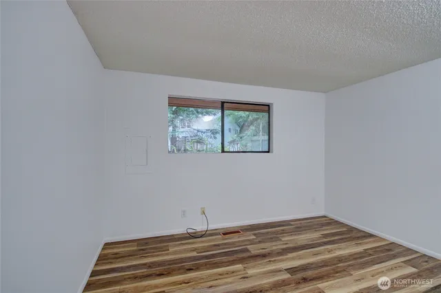 a view of a room with wooden floor and window