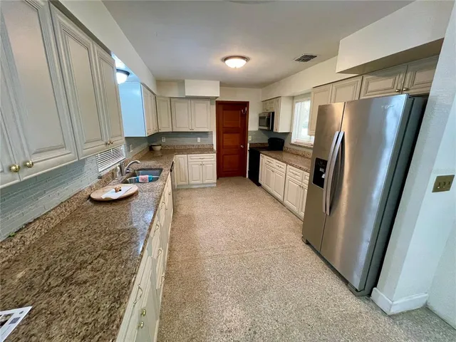 a kitchen with granite countertop white cabinets and white appliances