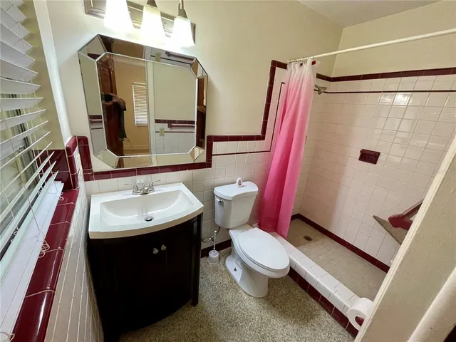 a bathroom with a toilet and a shower curtain