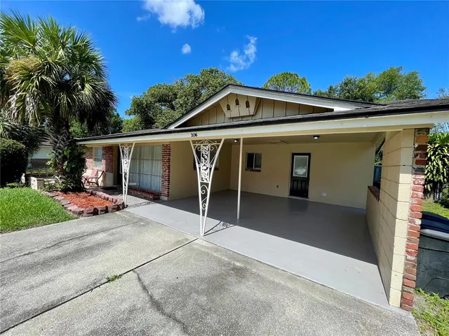a view of a house with a patio and a yard