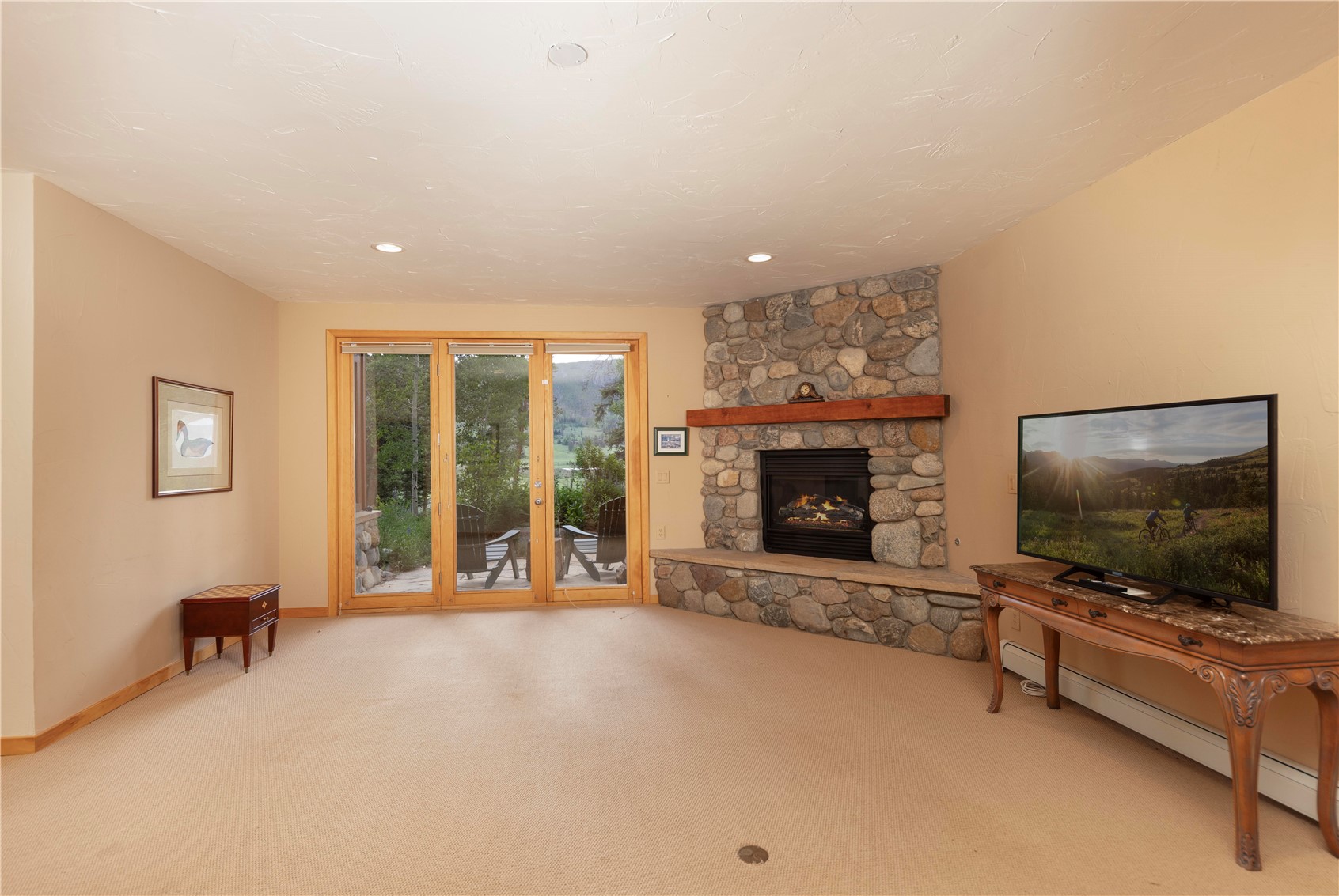 760 Penstemon Road Keystone, CO 80435 - Photo 27 of 39 Carpeted living room featuring baseboard heating and a stone fireplace