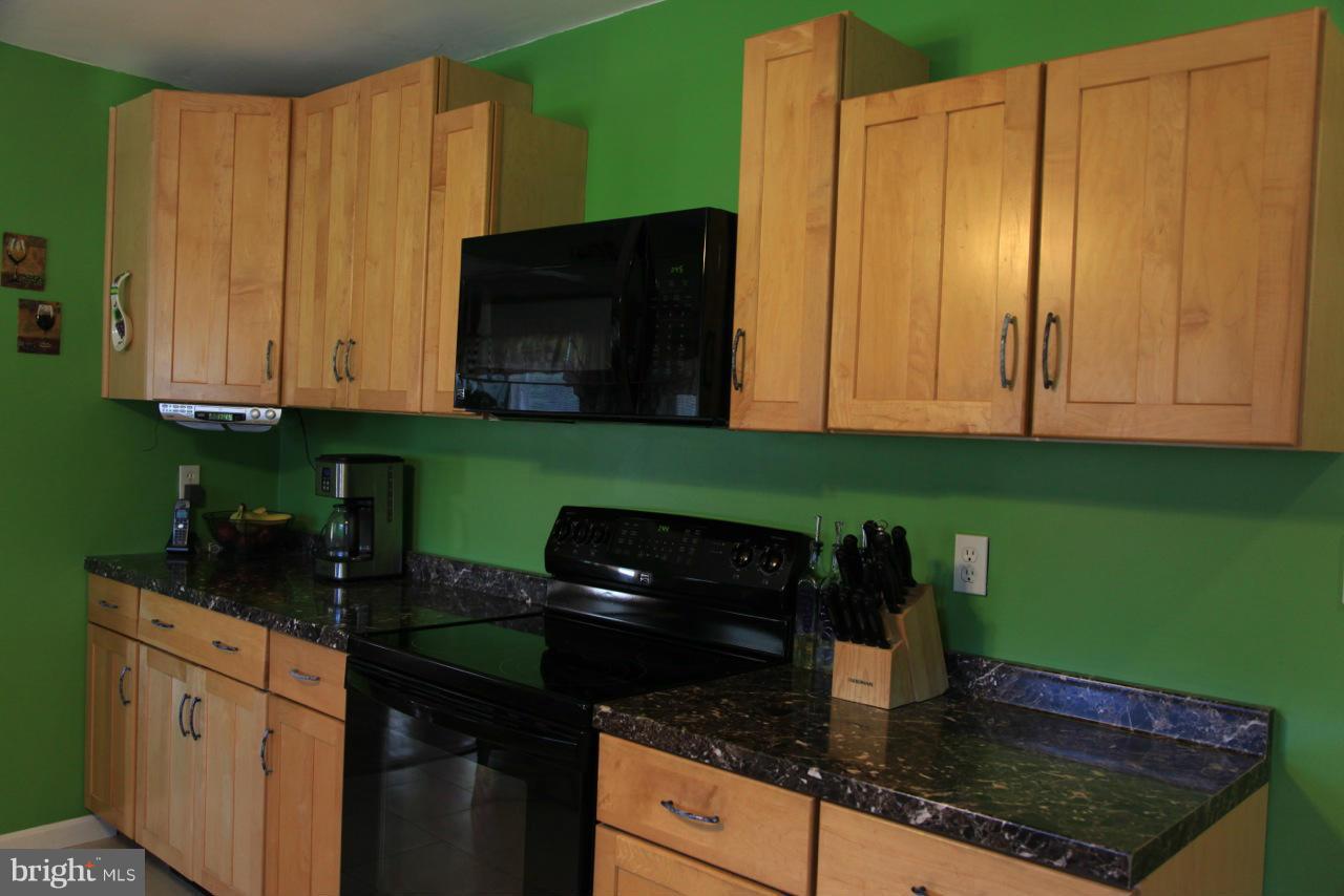 2122 Fallston Road Fallston, MD 21047 - Photo 13 of 30 a kitchen with granite countertop stainless steel appliances a stove a refrigerator a sink and dishwasher with wooden cabinets