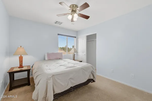 a bedroom with a bed and a ceiling fan