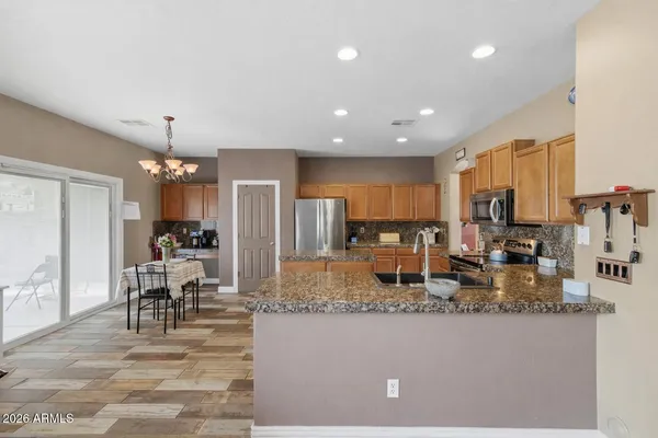 a kitchen with kitchen island granite countertop cabinets a dining table and chairs