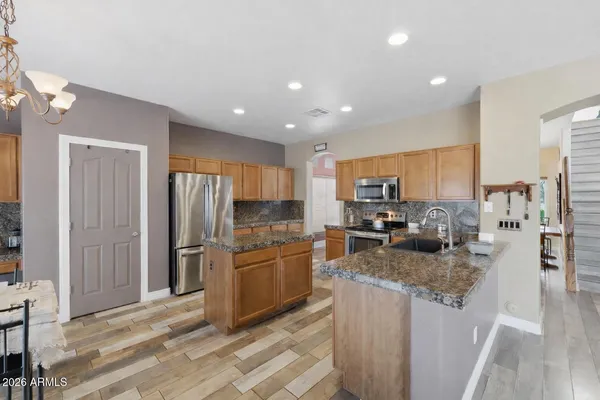 a kitchen with stainless steel appliances granite countertop a refrigerator stove microwave and sink