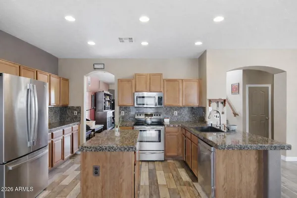 a kitchen with stainless steel appliances granite countertop a sink stove and refrigerator