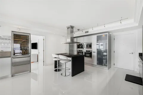a kitchen with stainless steel appliances kitchen island a refrigerator sink and stove