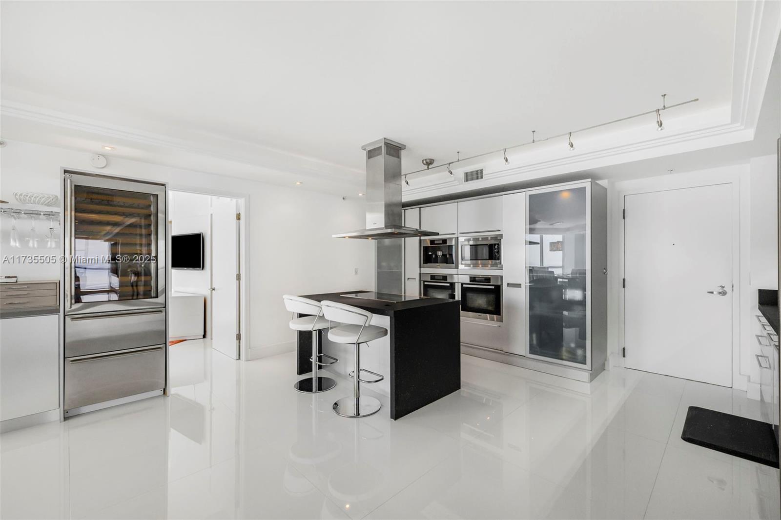 18201 Collins Avenue, Unit PH5109 Sunny Isles Beach, FL 33160 - Photo 17 of 53 a kitchen with stainless steel appliances kitchen island a refrigerator sink and stove