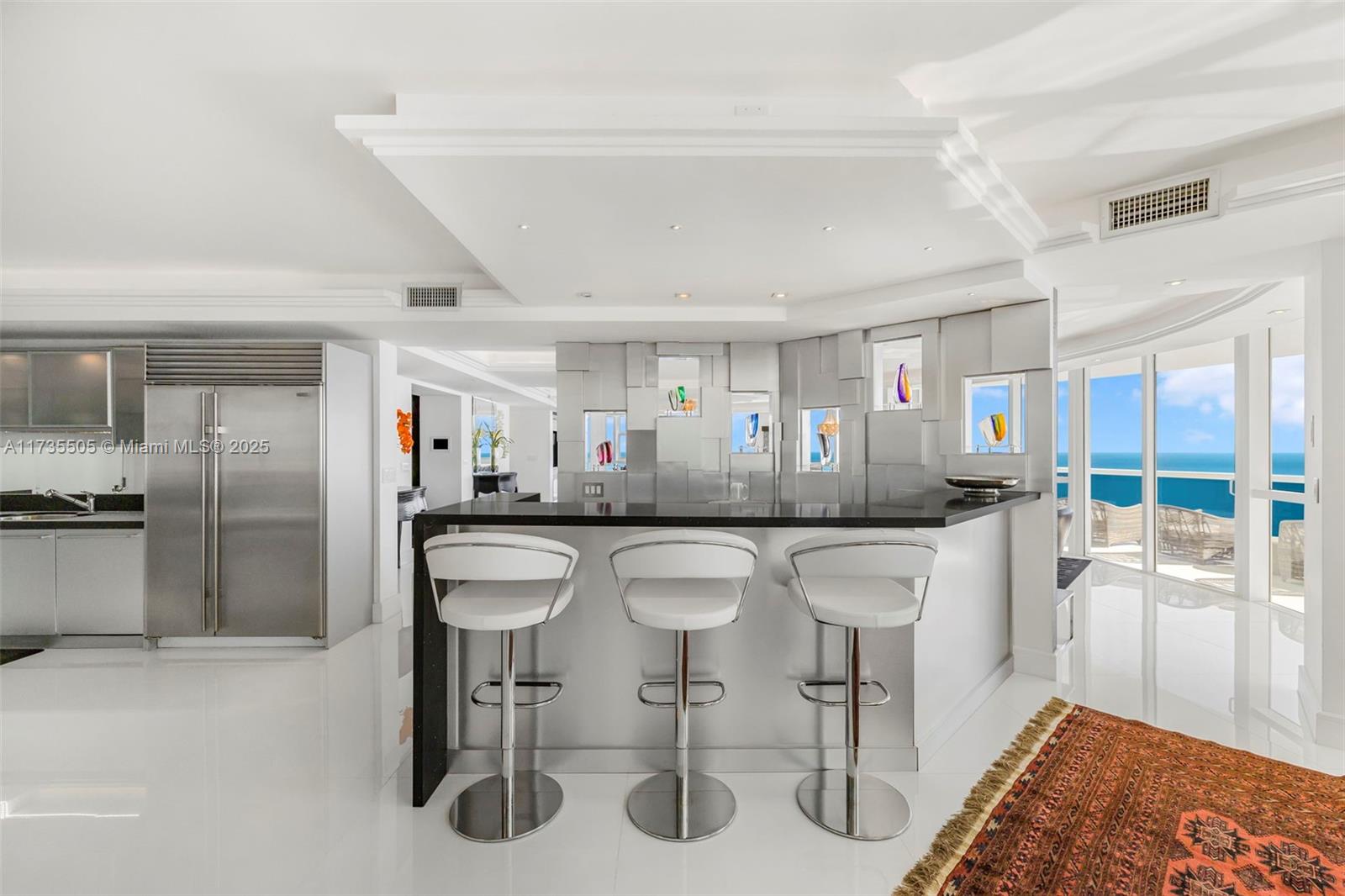 18201 Collins Avenue, Unit PH5109 Sunny Isles Beach, FL 33160 - Photo 20 of 53 a dining hall with stainless steel appliances kitchen island granite countertop a table chairs and a refrigerator