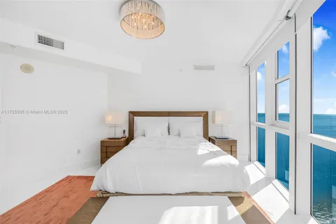 a large bed sitting in a bedroom next to a window