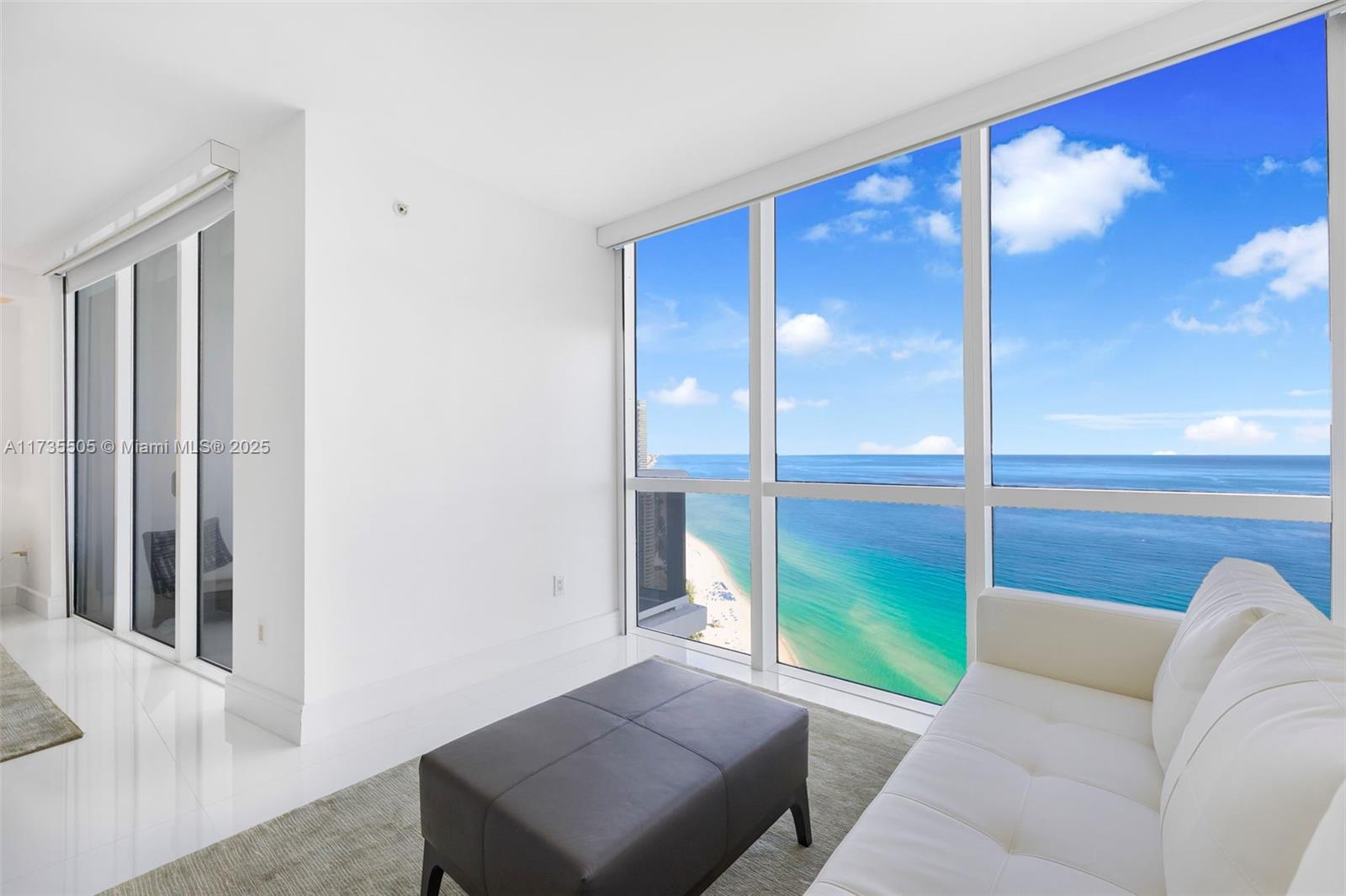 18201 Collins Avenue, Unit PH5109 Sunny Isles Beach, FL 33160 - Photo 34 of 53 a living room with a large window and a fireplace