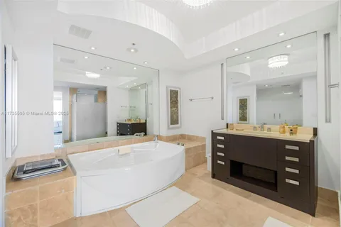 a spacious bathroom with a tub sink and mirror
