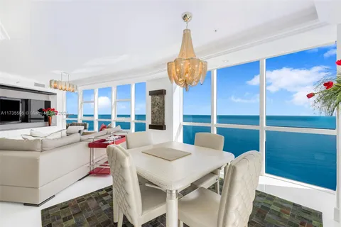 a view of a dining room with furniture a chandelier and wooden floor
