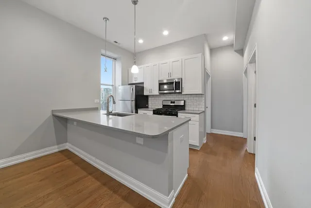 a kitchen with white cabinets and stainless steel appliances