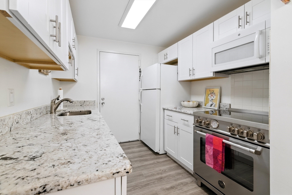 3 Post Oak Lane, Unit 1 Natick, MA 01760 - Photo 6 of 13 a kitchen with stainless steel appliances granite countertop a stove and a sink