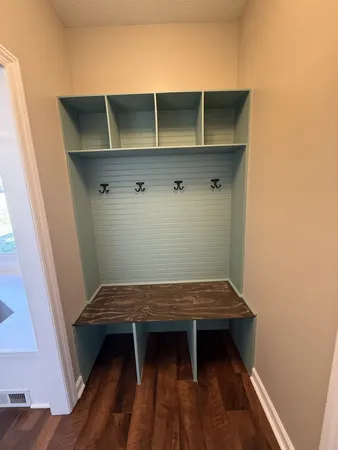 a view of a hall with wooden floor and windows