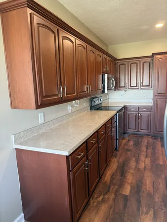 a view of kitchen with stainless steel appliances granite countertop sink and cabinets