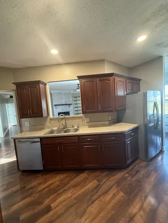 a kitchen with stainless steel appliances granite countertop a refrigerator and a stove