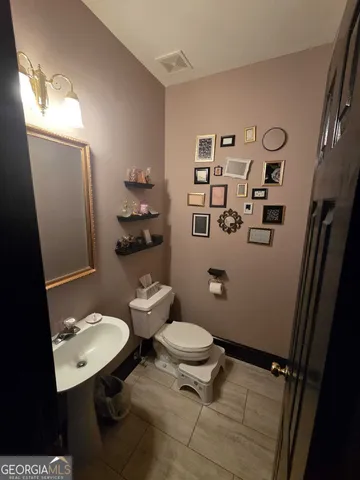 a bathroom with a sink toilet and a mirror