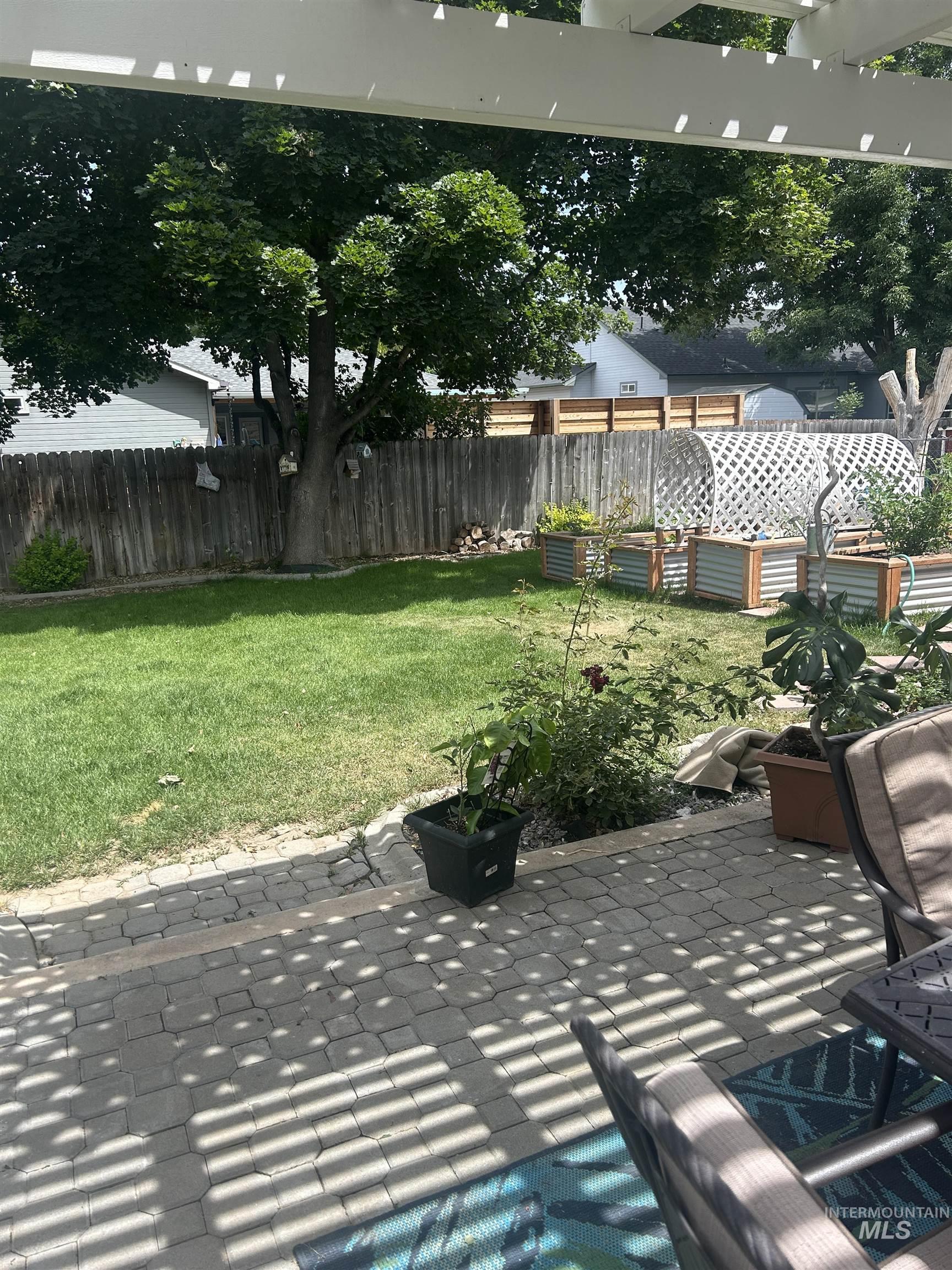 1444 East Doberman Street Meridian, ID 83642 - Photo 26 of 31 Paved patio area featuring an overhead pergola structure and a spacious lawn