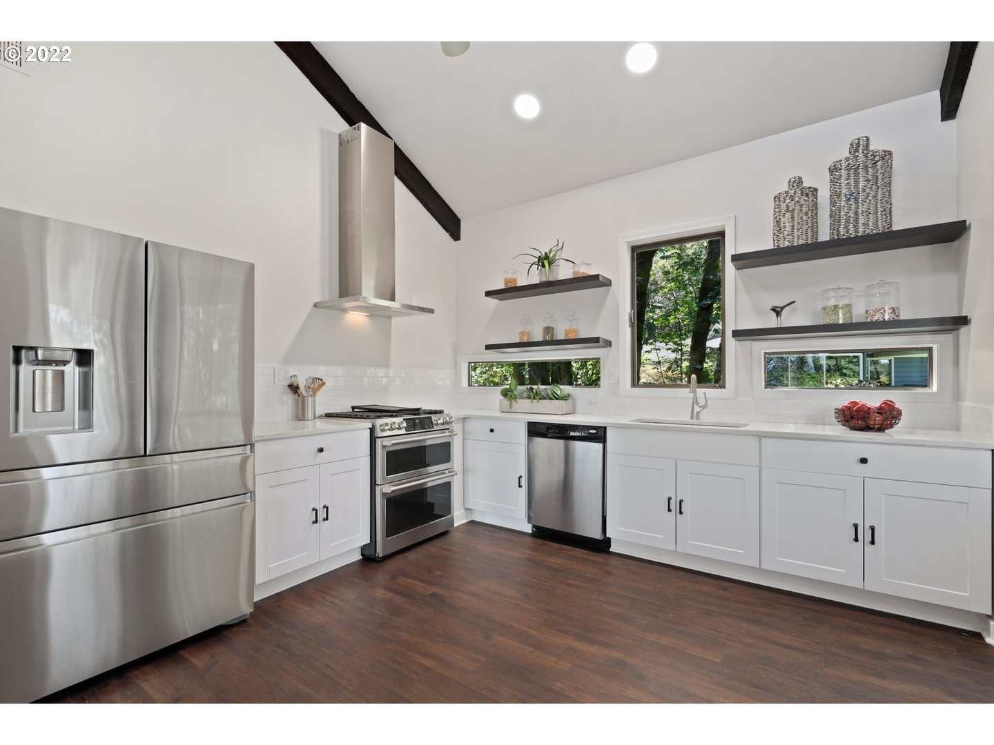 3143 Southwest Sherwood Place Portland, OR 97201 - Photo 7 of 32 a kitchen with white cabinets and stainless steel appliances