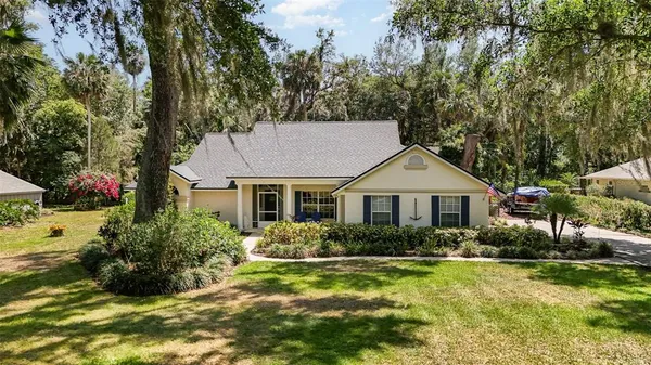 a view of a house with a yard and potted plants