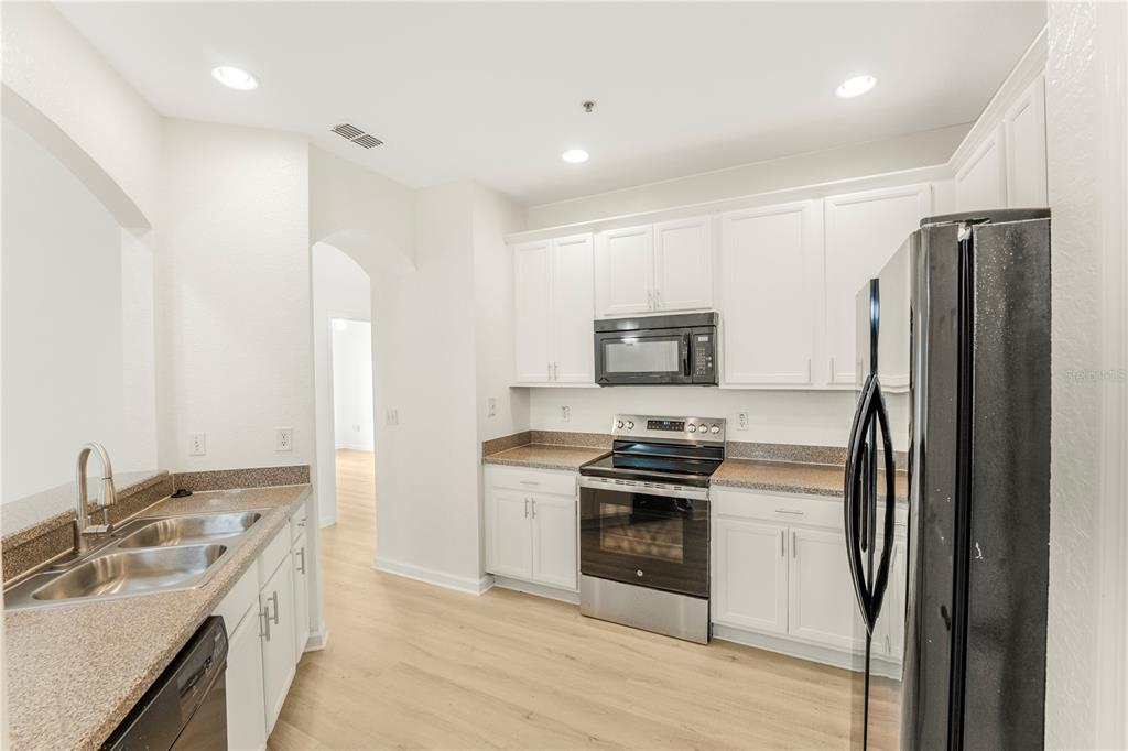 3351 Whitestone Circle, Unit 304 Kissimmee, FL 34741 - Photo 4 of 21 a kitchen with stainless steel appliances granite countertop a refrigerator stove and sink