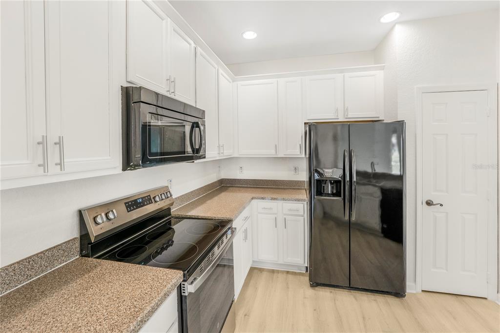 3351 Whitestone Circle, Unit 304 Kissimmee, FL 34741 - Photo 5 of 21 a kitchen with a refrigerator stove and microwave