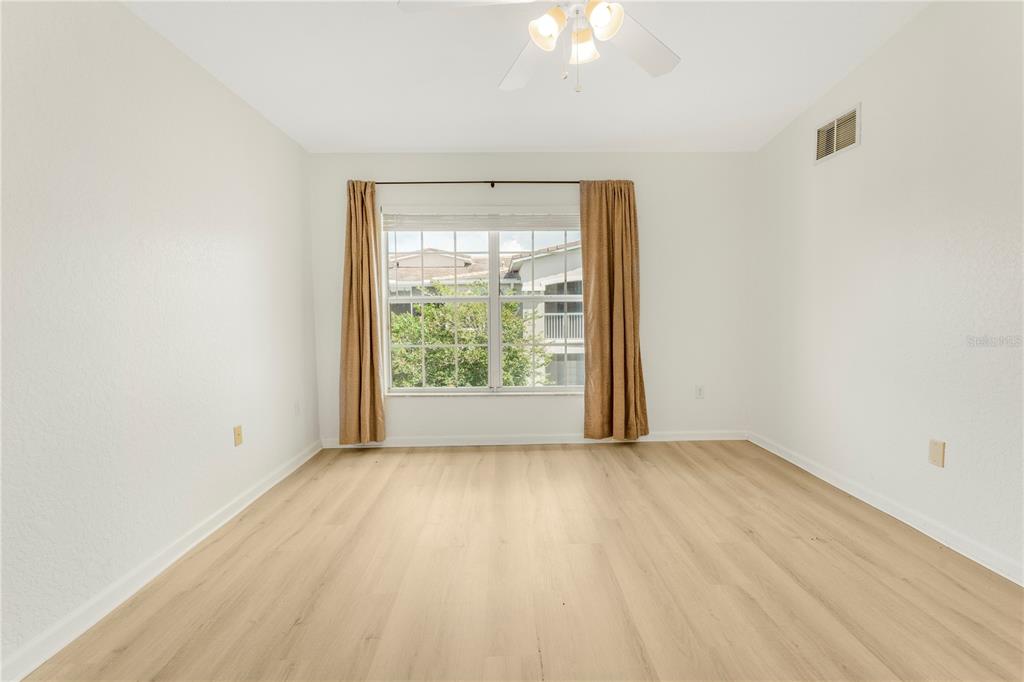 3351 Whitestone Circle, Unit 304 Kissimmee, FL 34741 - Photo 8 of 21 an empty room with wooden floor and windows