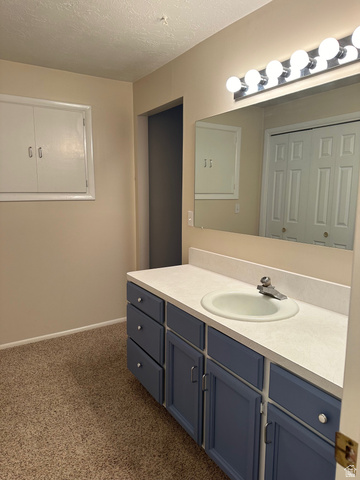 254 Meadow Lane Centerville, UT 84014 - Photo 19 of 34 Bathroom vanity featuring a single basin sink, light-colored countertop, and a row of vanity lights