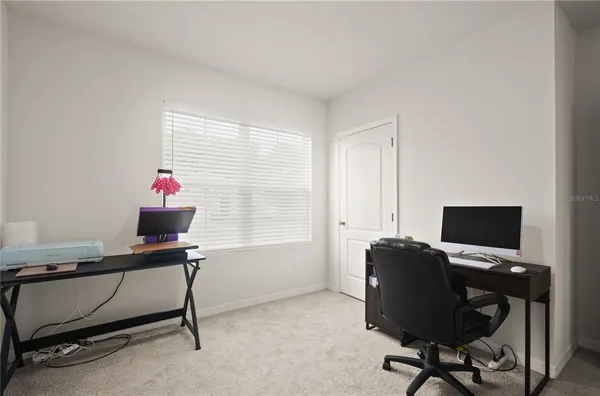 a view of a workspace with furniture and a window