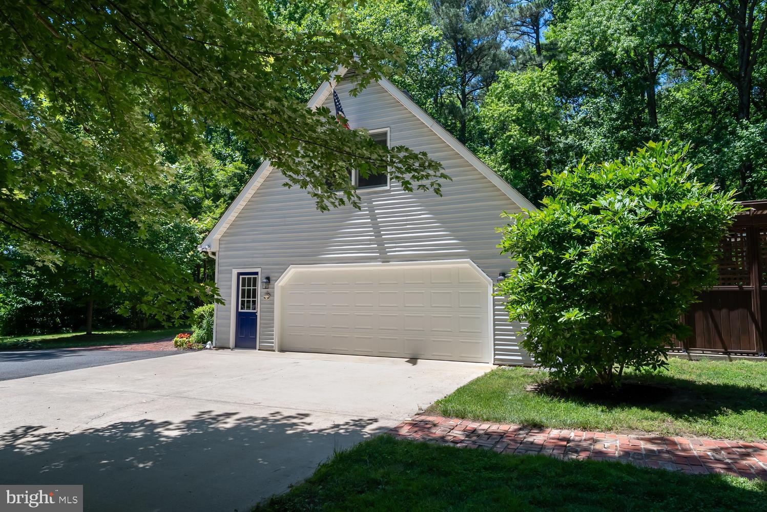814 Wrights Neck Road Centreville, MD 21617 - Photo 4 of 53 a front view of a house with a yard and garage