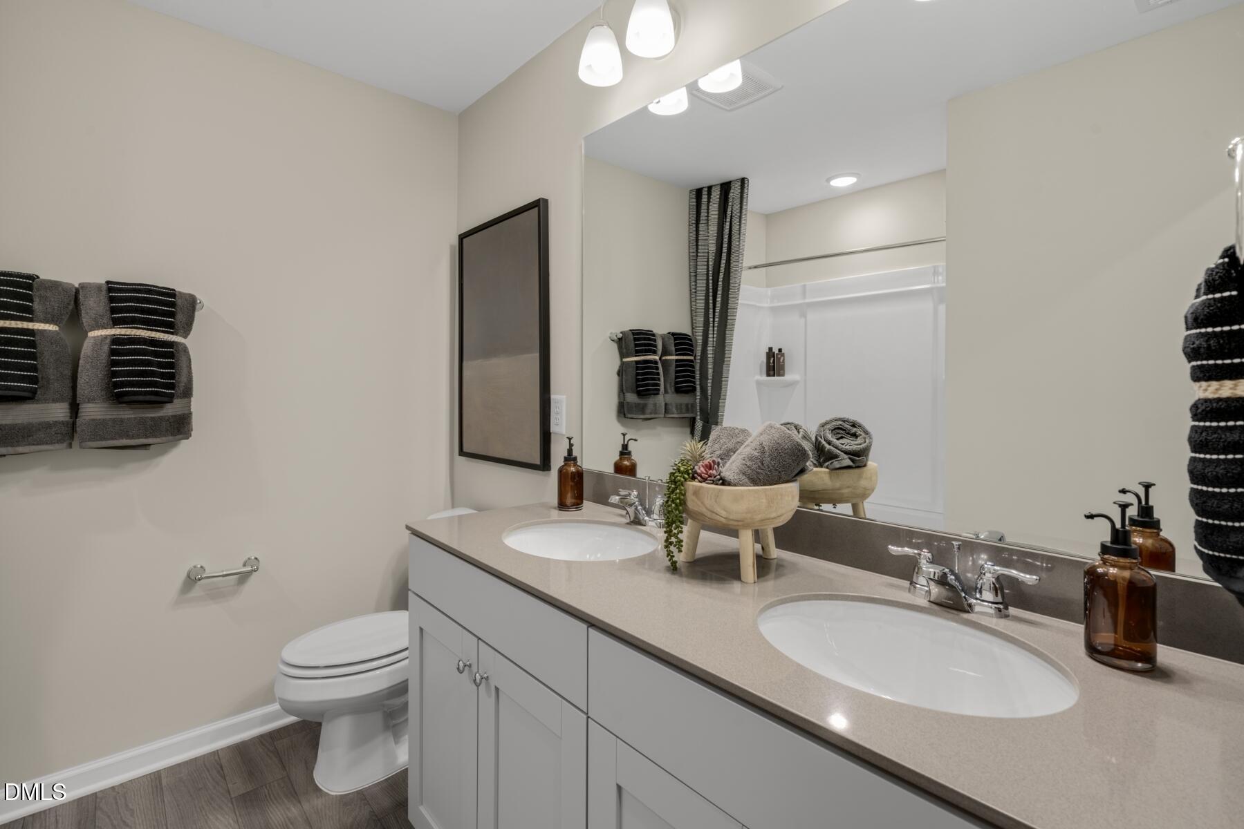 136 Lennei Lane Garner, NC 27529 - Photo 5 of 30 a bathroom with a double vanity sink toilet and mirror