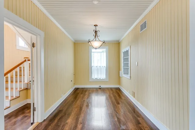 a view of empty room with wooden floor and windows