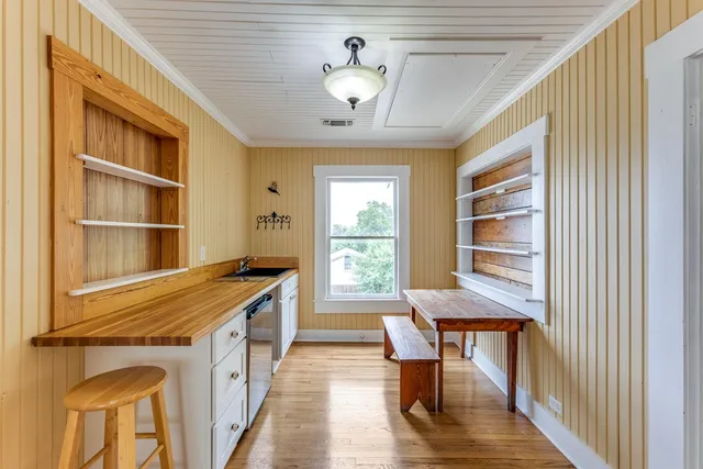 a large kitchen with cabinets wooden floor and stainless steel appliances