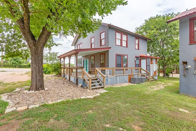 a view of a house with backyard and a tree